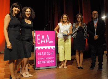 People posing on stage with an EAA award